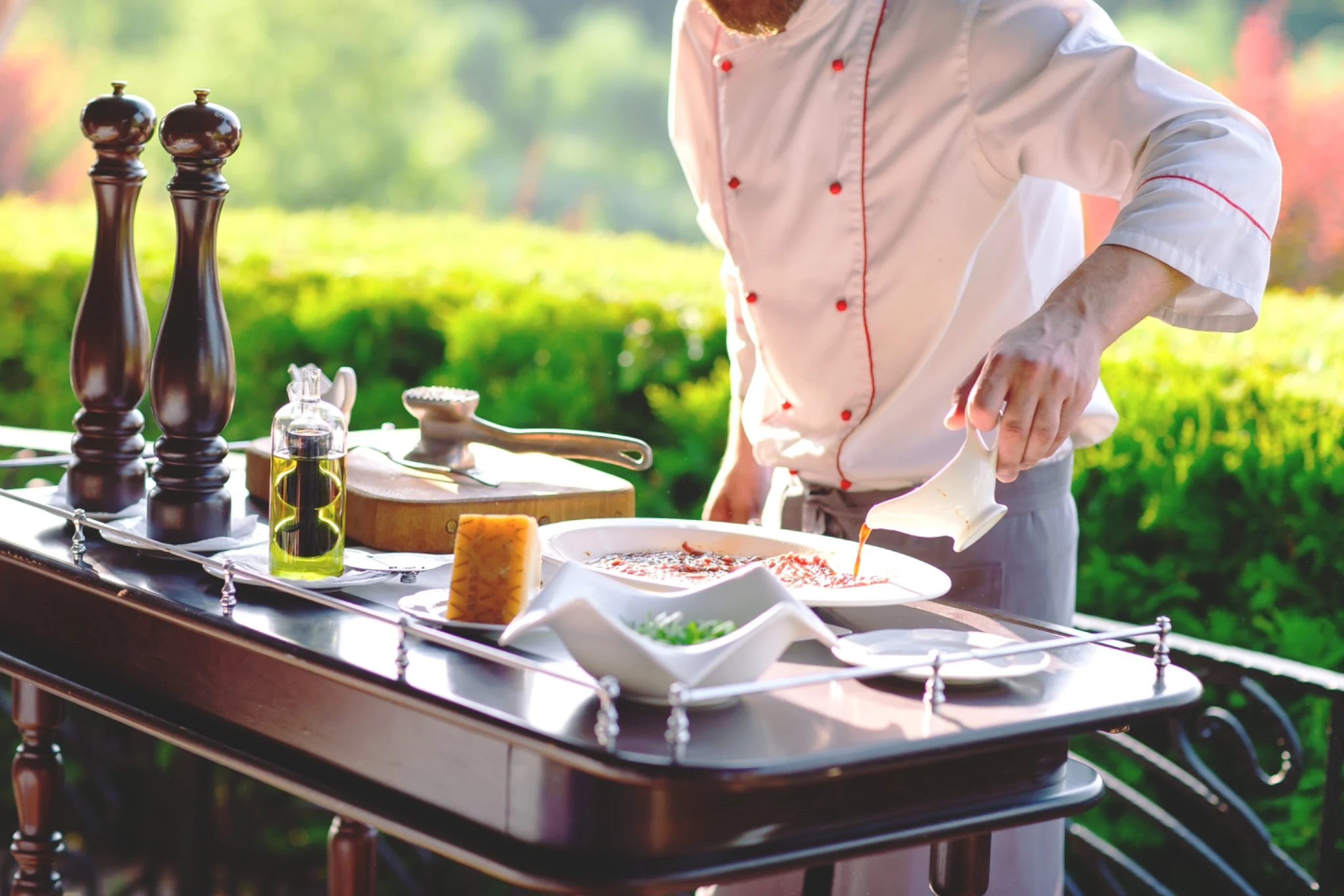 A chef preparing a dish outdoors, reflecting Quintessencia’s personal and experiential approach to dining.